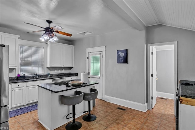 118 Saint James Ave, Suffolk, VA 23434 - kitchen featuring white cabinetry, a ceiling fan, a kitchen island, a breakfast bar, and vaulted ceiling