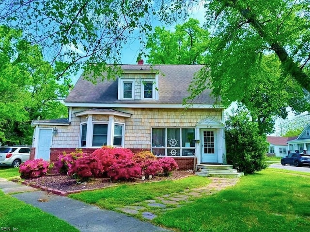 9549 Statler St, Norfolk, VA 23503 - view of front of house with a front lawn, a chimney, and roof with shingles