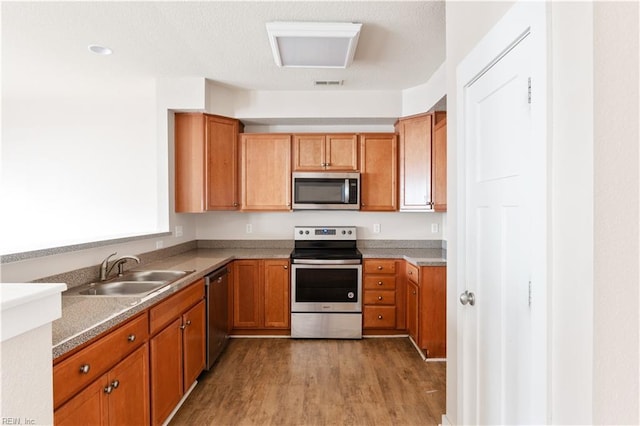 222 Craftsman Cir, Suffolk, VA 23434 - kitchen featuring appliances with stainless steel finishes, light wood-style floors, and brown cabinetry