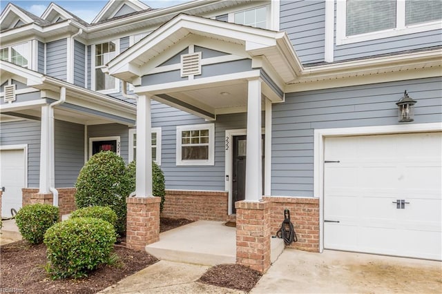 222 Craftsman Cir, Suffolk, VA 23434 - view of exterior entry featuring a garage, brick siding, and a porch