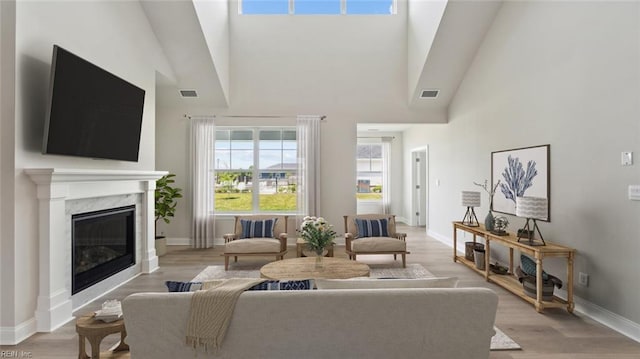 2017 Munro Ln, Chesapeake, VA 23322 - living room featuring a towering ceiling, light wood-style flooring, and a high end fireplace
