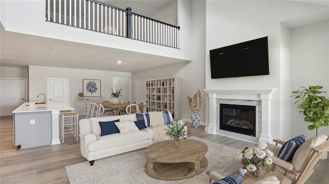 2017 Munro Ln, Chesapeake, VA 23322 - living room with light wood-style floors, a fireplace, a high ceiling, and recessed lighting