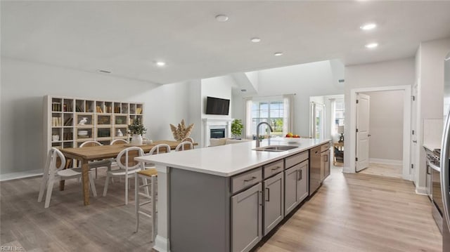 2017 Munro Ln, Chesapeake, VA 23322 - kitchen with gray cabinets, dishwasher, a kitchen island with sink, light countertops, and a fireplace
