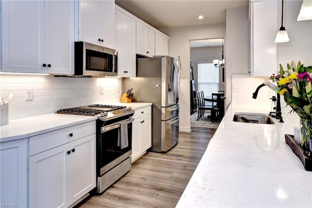 134 Fishermans Way, Poquoson, VA 23662 - kitchen with appliances with stainless steel finishes, light countertops, light wood-type flooring, white cabinetry, and decorative backsplash