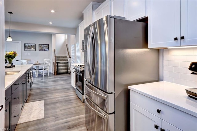 134 Fishermans Way, Poquoson, VA 23662 - kitchen with appliances with stainless steel finishes, white cabinets, light countertops, tasteful backsplash, and hanging light fixtures