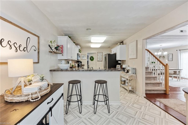 6729 Hampton Roads Pkwy Unit D, Suffolk, VA 23435 - kitchen with freestanding refrigerator, a chandelier, white cabinetry, and light floors