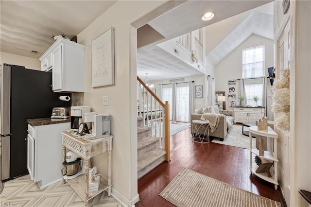 6729 Hampton Roads Pkwy Unit D, Suffolk, VA 23435 - kitchen featuring white cabinets, dark countertops, open floor plan, light wood finished floors, and lofted ceiling