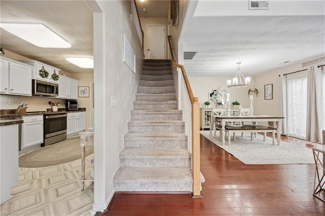 6729 Hampton Roads Pkwy Unit D, Suffolk, VA 23435 - stairway with wood finished floors and a chandelier