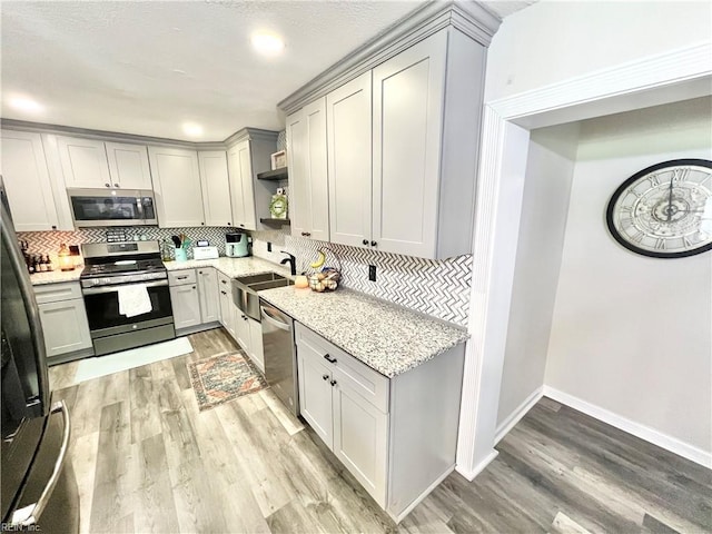 969 Westerly Trl, Virginia Beach, VA 23464 - kitchen with appliances with stainless steel finishes, open shelves, light wood finished floors, decorative backsplash, and recessed lighting