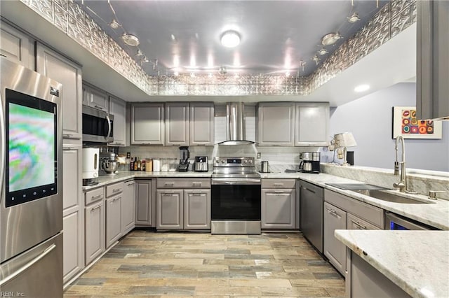 106 Genoa Dr, Hampton, VA 23664 - kitchen featuring appliances with stainless steel finishes, gray cabinets, light wood-style flooring, wall chimney range hood, and tasteful backsplash