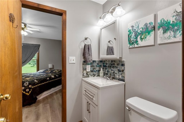 11855 Harcum Rd, Gloucester, VA 23061 - bathroom with wood finished floors, vanity, tasteful backsplash, and connected bathroom