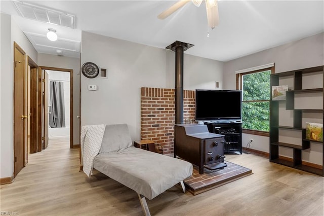 11855 Harcum Rd, Gloucester, VA 23061 - living room with a wood stove, light wood finished floors, and a ceiling fan