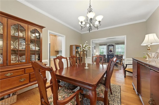 2152 Benomi Dr, Williamsburg, VA 23185 - dining room featuring a chandelier, light wood-style flooring, crown molding, and a wainscoted wall