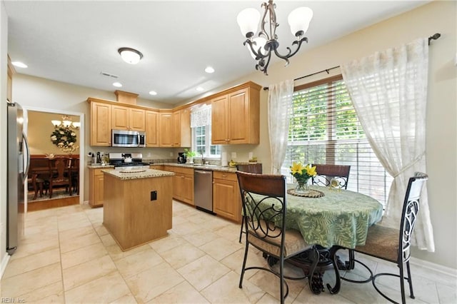 2152 Benomi Dr, Williamsburg, VA 23185 - kitchen featuring appliances with stainless steel finishes, a center island, a chandelier, light stone counters, and hanging light fixtures