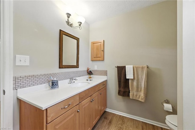 2152 Benomi Dr, Williamsburg, VA 23185 - bathroom with vanity, wood finished floors, decorative backsplash, and a textured ceiling