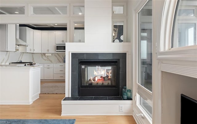 119 Grand View Dr, Hampton, VA 23664 - detailed view of wood finished floors, a tiled fireplace, and wall chimney range hood