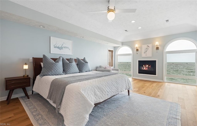119 Grand View Dr, Hampton, VA 23664 - bedroom featuring wood finished floors, a textured ceiling, a glass covered fireplace, ceiling fan, and recessed lighting