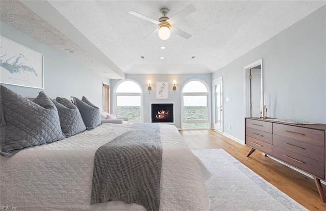 119 Grand View Dr, Hampton, VA 23664 - bedroom with light wood finished floors, a warm lit fireplace, recessed lighting, a ceiling fan, and a textured ceiling