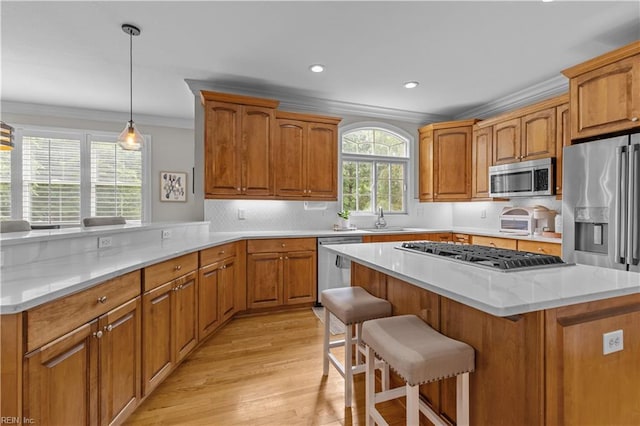 860 Greenfield Ln, Chesapeake, VA 23322 - kitchen with appliances with stainless steel finishes, ornamental molding, light wood finished floors, a breakfast bar, and brown cabinets