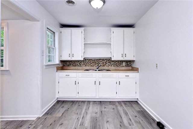 513 W Maynor Dr, Williamsburg, VA 23185 - kitchen with open shelves, light wood-style floors, white cabinetry, tasteful backsplash, and light countertops