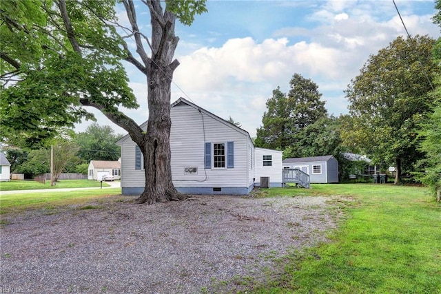 513 W Maynor Dr, Williamsburg, VA 23185 - view of property exterior featuring a storage unit, a lawn, crawl space, and a deck