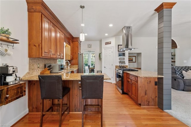 713 Tupelo Xing, Chesapeake, VA 23320 - kitchen featuring wall chimney exhaust hood, appliances with stainless steel finishes, a peninsula, ornate columns, and light stone counters