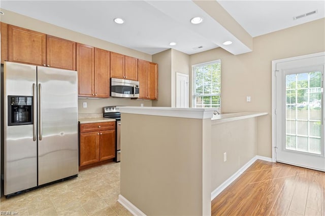 1439 Otterbourne Cir, Chesapeake, VA 23320 - kitchen featuring appliances with stainless steel finishes, brown cabinets, light countertops, recessed lighting, and a peninsula