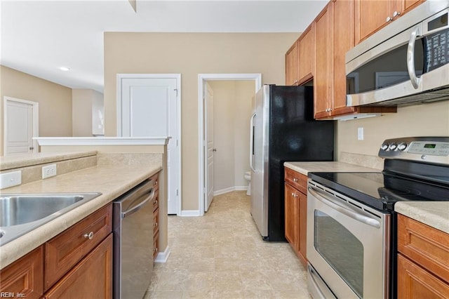 1439 Otterbourne Cir, Chesapeake, VA 23320 - kitchen with stainless steel appliances, brown cabinetry, light countertops, and recessed lighting