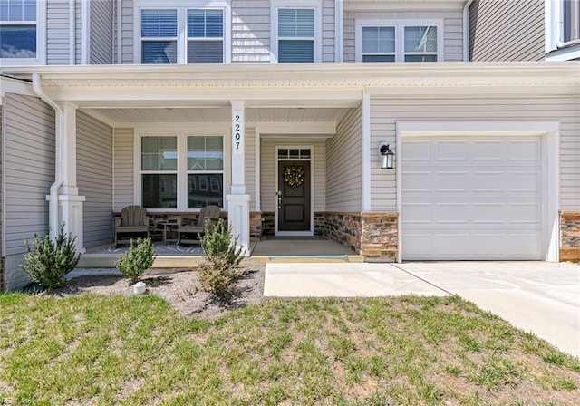 2207 Fallon Cir, Williamsburg, VA 23188 - property entrance with covered porch, concrete driveway, and a garage