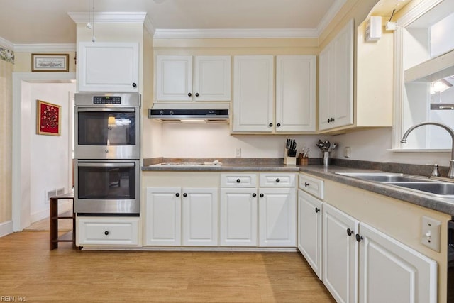32391 S Main St, Boykins, VA 23827 - kitchen with double oven, light wood finished floors, dark countertops, white gas stovetop, and white cabinetry