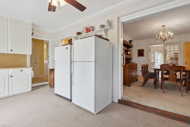 32391 S Main St, Boykins, VA 23827 - kitchen with freestanding refrigerator, light carpet, a chandelier, a ceiling fan, and crown molding
