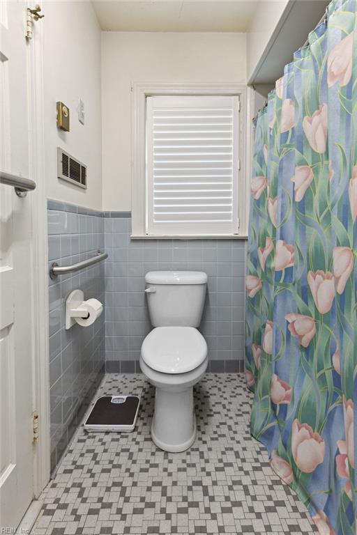 32391 S Main St, Boykins, VA 23827 - full bath featuring wainscoting, tile walls, and curtained shower