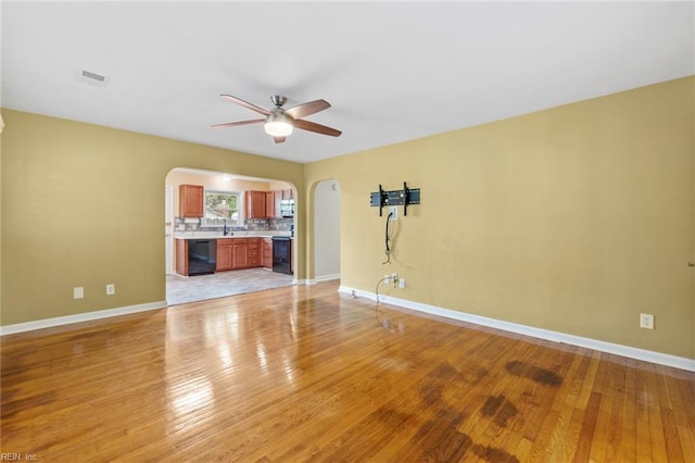2655 Village Ave, Chesapeake, VA 23323 - unfurnished living room with arched walkways, a ceiling fan, and light wood-type flooring
