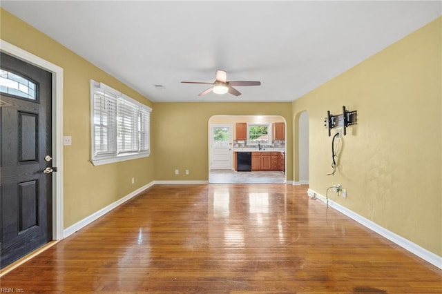 2655 Village Ave, Chesapeake, VA 23323 - unfurnished living room with arched walkways, a ceiling fan, and light wood-style floors