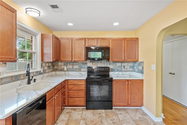2655 Village Ave, Chesapeake, VA 23323 - kitchen with black appliances, light stone counters, tasteful backsplash, brown cabinetry, and recessed lighting