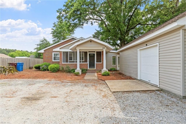 2655 Village Ave, Chesapeake, VA 23323 - view of front of house with gravel driveway, brick siding, and a garage