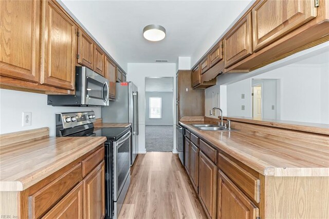 284 Windbrooke Ln, Virginia Beach, VA 23462 - kitchen featuring appliances with stainless steel finishes, light wood-style flooring, a peninsula, and butcher block countertops