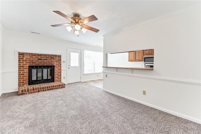 284 Windbrooke Ln, Virginia Beach, VA 23462 - unfurnished living room featuring light colored carpet, a ceiling fan, crown molding, and a brick fireplace