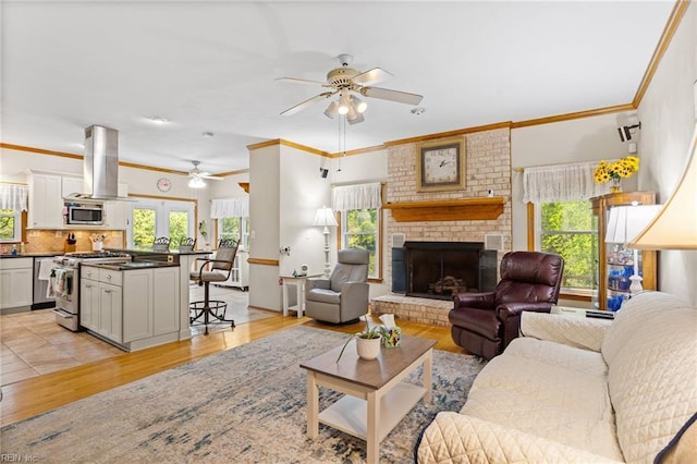801 Kings Creek Dr, Virginia Beach, VA 23464 - living room featuring a ceiling fan, a brick fireplace, light wood finished floors, and crown molding