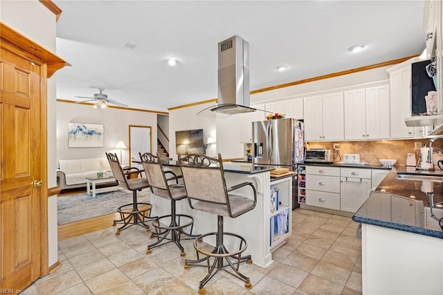 801 Kings Creek Dr, Virginia Beach, VA 23464 - kitchen with island range hood, a breakfast bar area, ornamental molding, white cabinetry, and ceiling fan