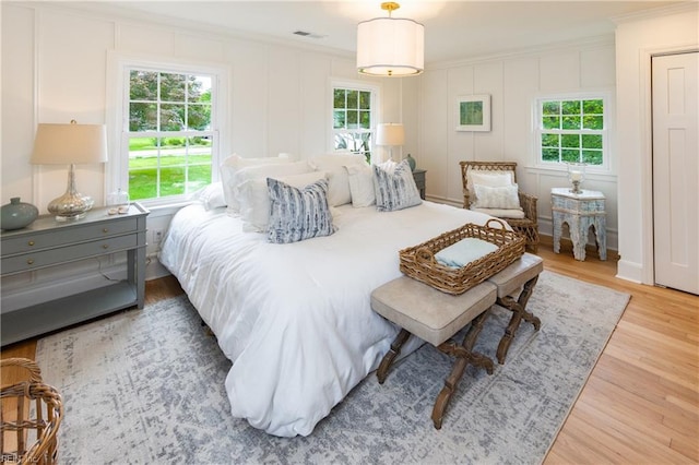 1009 Abingdon Rd, Virginia Beach, VA 23451 - bedroom with ornamental molding, multiple windows, a decorative wall, and wood finished floors