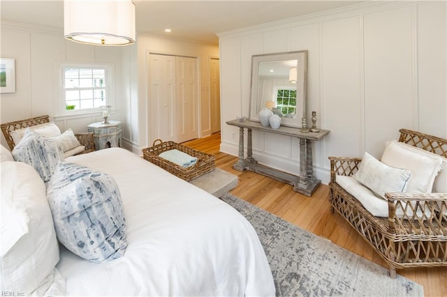 1009 Abingdon Rd, Virginia Beach, VA 23451 - bedroom featuring light wood-type flooring, ornamental molding, a decorative wall, and multiple closets