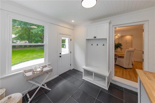 1009 Abingdon Rd, Virginia Beach, VA 23451 - mudroom with dark tile patterned floors, crown molding, and a chandelier