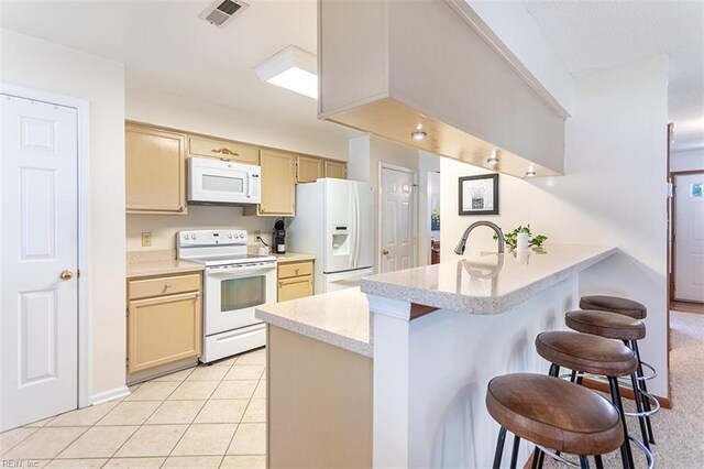 13 Fawn Cir, Hampton, VA 23666 - kitchen with white appliances, a peninsula, a kitchen breakfast bar, light countertops, and light tile patterned flooring