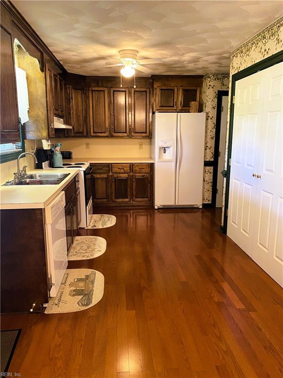 2016 Kilby Ln, Suffolk, VA 23434 - kitchen with white appliances, under cabinet range hood, wallpapered walls, a ceiling fan, and light countertops