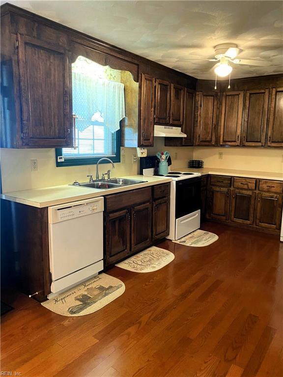 2016 Kilby Ln, Suffolk, VA 23434 - kitchen with white appliances, under cabinet range hood, light countertops, and dark brown cabinetry