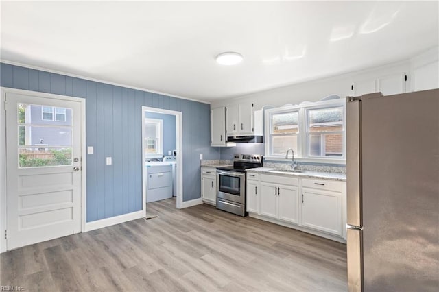 3033 Williams St, Newport News, VA 23607 - kitchen featuring appliances with stainless steel finishes, white cabinetry, washer and clothes dryer, light wood-style floors, and under cabinet range hood
