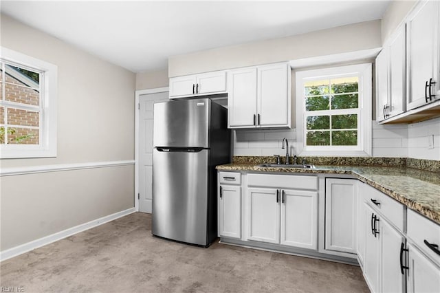 2822 Beachmont Ave, Norfolk, VA 23504 - kitchen with freestanding refrigerator, dark stone counters, tasteful backsplash, white cabinetry, and concrete floors