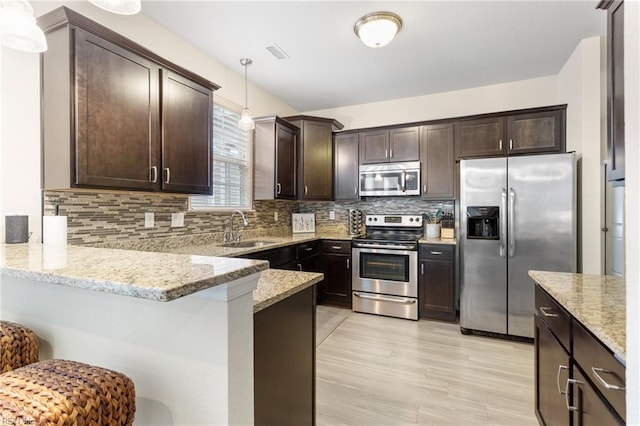 2816 Gavin Rd Unit 14, Chesapeake, VA 23323 - kitchen featuring appliances with stainless steel finishes, dark brown cabinets, light stone counters, and hanging light fixtures
