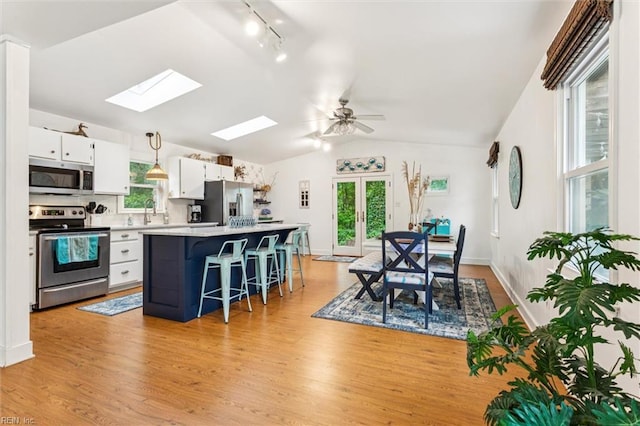 682 Bay Port Rd, Jamaica, VA 23079 - kitchen with appliances with stainless steel finishes, lofted ceiling, rail lighting, a center island, and white cabinetry